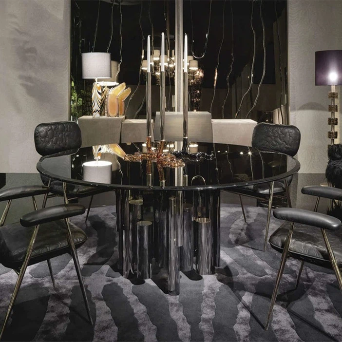 Contemporary glass top dining table with gold metal base in modern luxury dining room setting. Contemporary glass top dining table with gold metal base in modern luxury dining room setting.